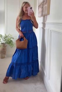 Woman in a blue tiered maxi skirt and matching crop top.