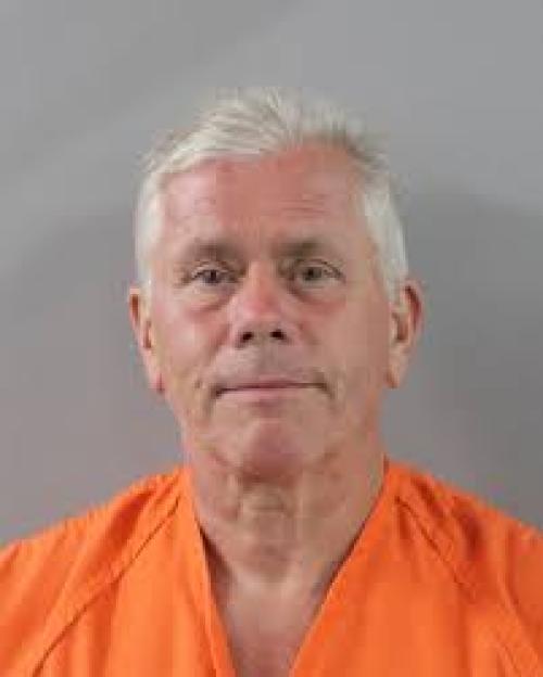 Mugshot of a man in an orange jumpsuit.