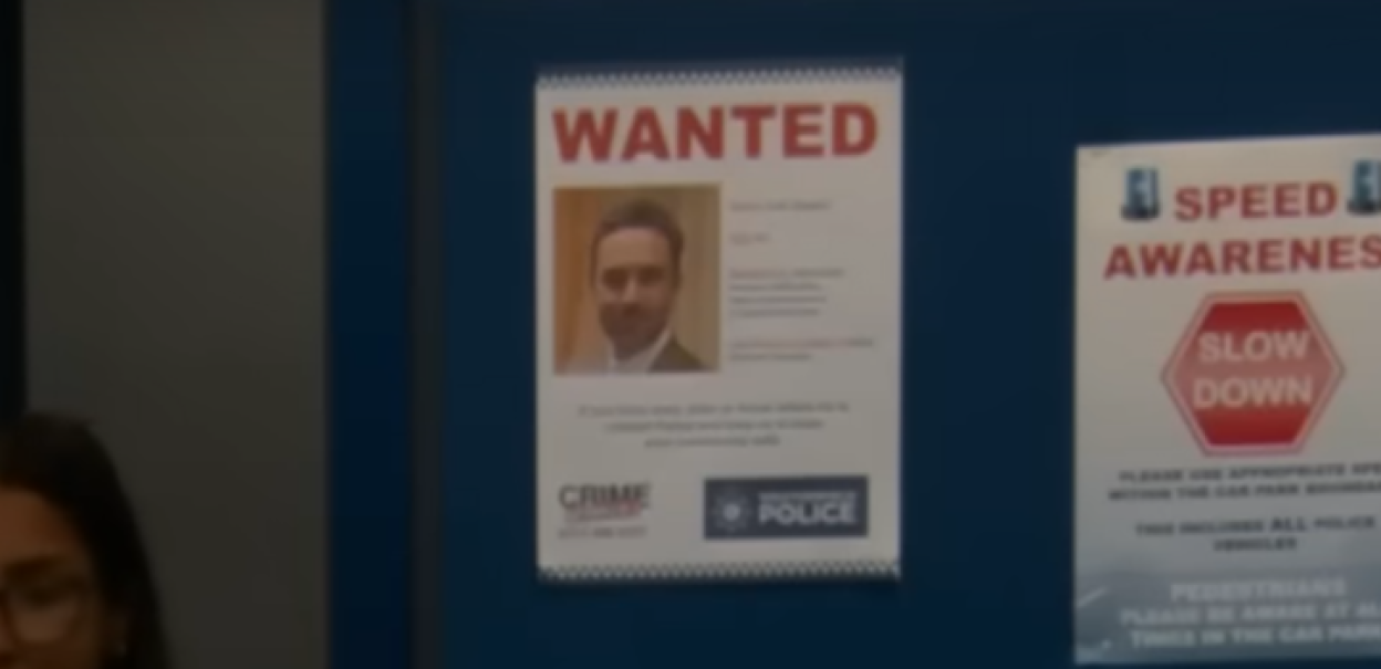 "Wanted" poster featuring a man with a beard and dark hair, next to a "Speed Awareness" poster with a "Slow Down" sign.
