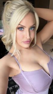 a woman with blonde hair and blue eyes is wearing a purple dress