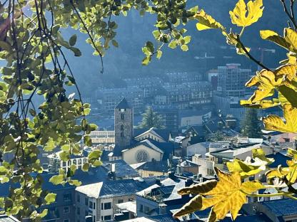 Panorama of Andorra la Vella, seen through tree branches.