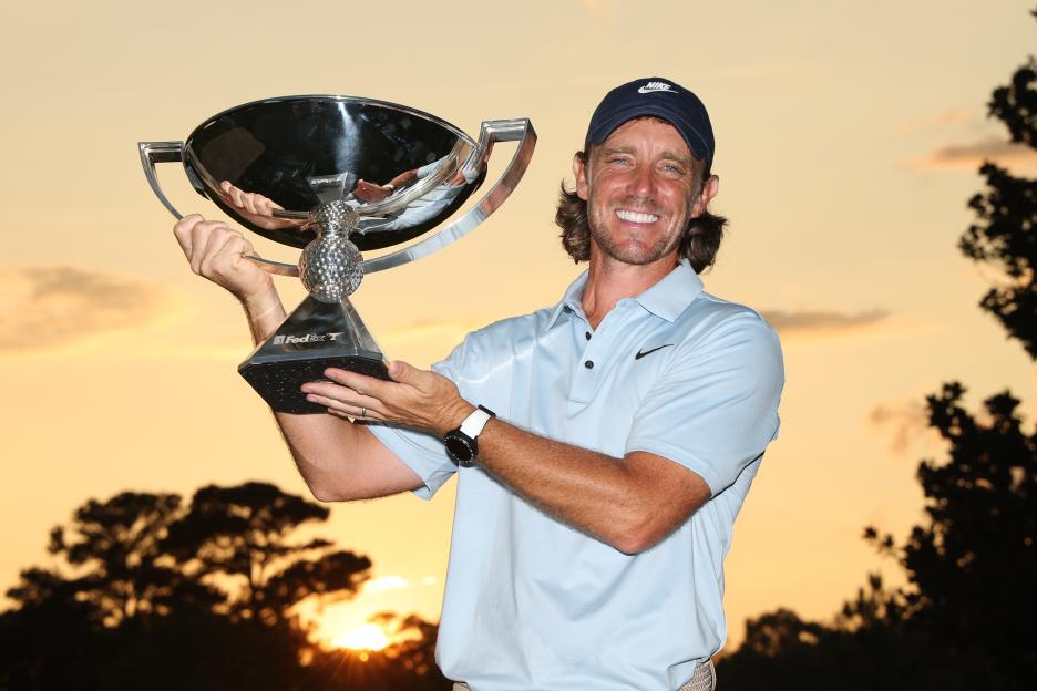 Tommy Fleetwood holding the FedEx Cup trophy.