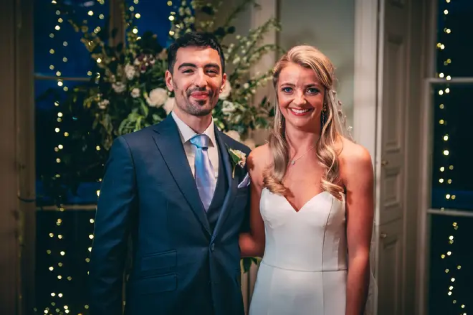 a bride and groom are posing for a picture at their wedding reception .