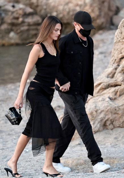 Jeff Bezos and Lauren Sanchez holding hands while walking.