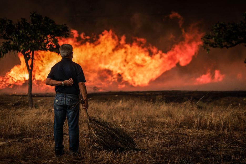 Man watching a large forest fire.