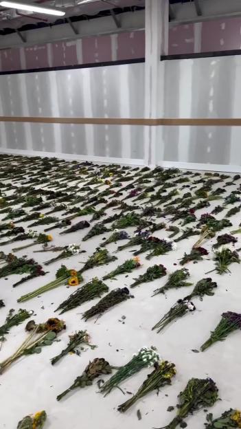 Numerous wilted flower bouquets laid on the floor.