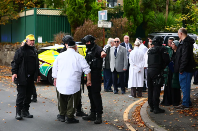 Police and members of the Jewish community at a street gathering.