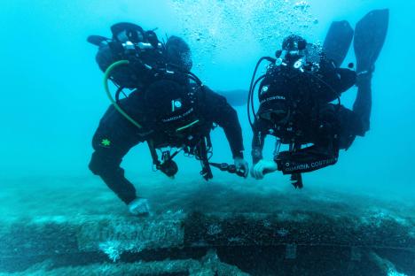 Two divers examining the sunken Bayesian yacht.