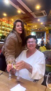Imogen Thomas and her mother toasting with wine glasses.
