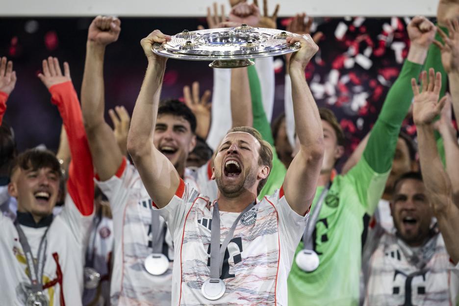 Harry Kane of FC Bayern München lifts the Meisterschale trophy.