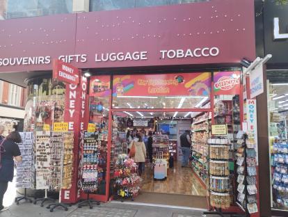 Exterior view of a gift shop selling souvenirs, tobacco, and offering money exchange.