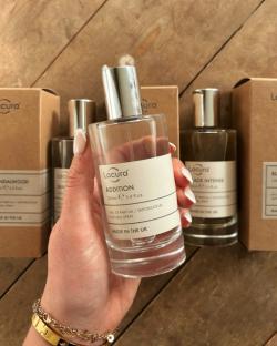 Hand holding Lacura Addition perfume.