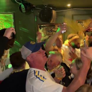 Leeds United fans celebrating in a pub.