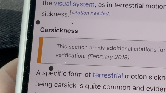 Close-up photo of a phone screen showing a Wikipedia article about carsickness.
