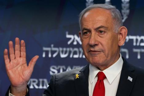 Benjamin Netanyahu raising his hand at a press conference.