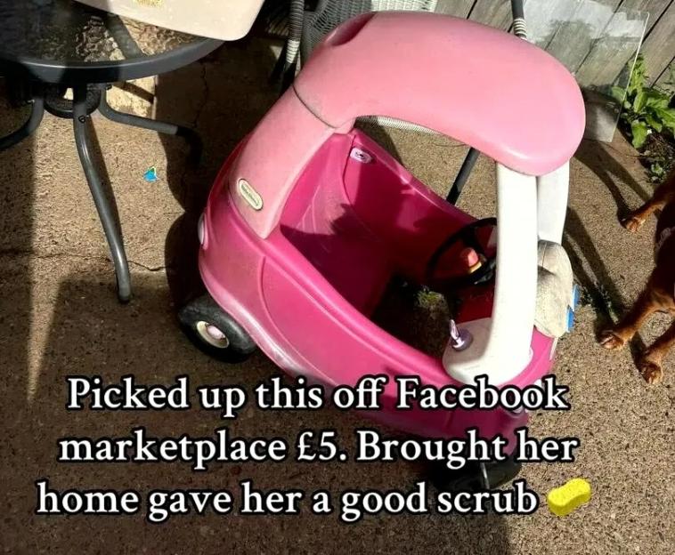 A pink Little Tikes car and a basin of soapy water with two sponges on an outdoor patio.
