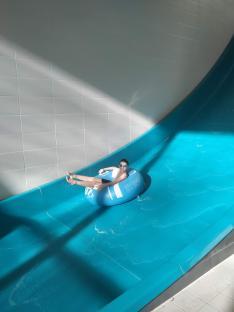 Boy on a water slide in an inner tube.