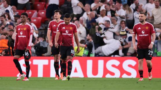 Manchester United soccer players walking off the field.