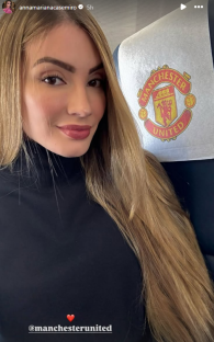 Woman with long blonde hair sitting in a seat with the Manchester United logo.