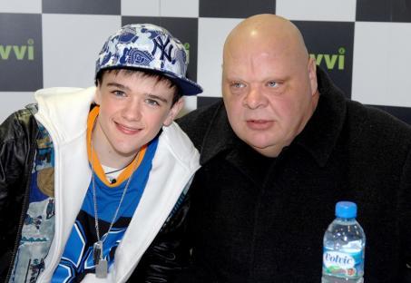 MANCHESTER, UNITED KINGDOM - NOVEMBER 24: George Sampson is protected by Simon Cowell's bodyguard Tony Adkins while signing copies of his new single 'Get Up On The Dance Floor/Headz Up' at Zavvi on November 24, 2008 in Manchester, England. (Photo by Shirlaine Forrest/WireImage)