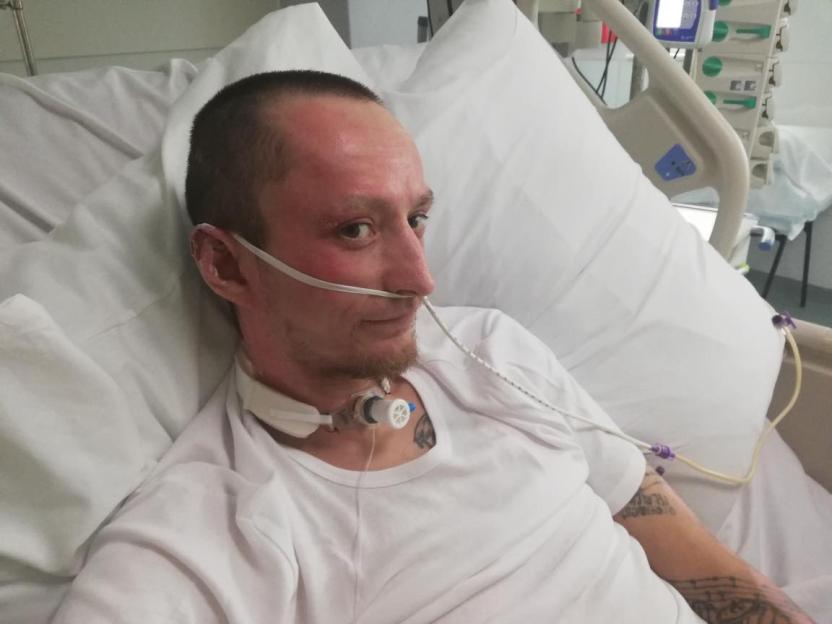 Man in hospital bed recovering from injuries.
