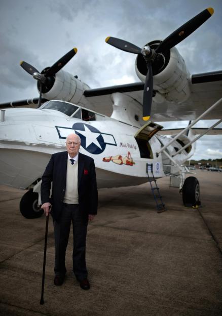 Elderly man with cane standing in front of a Catalina aircraft.