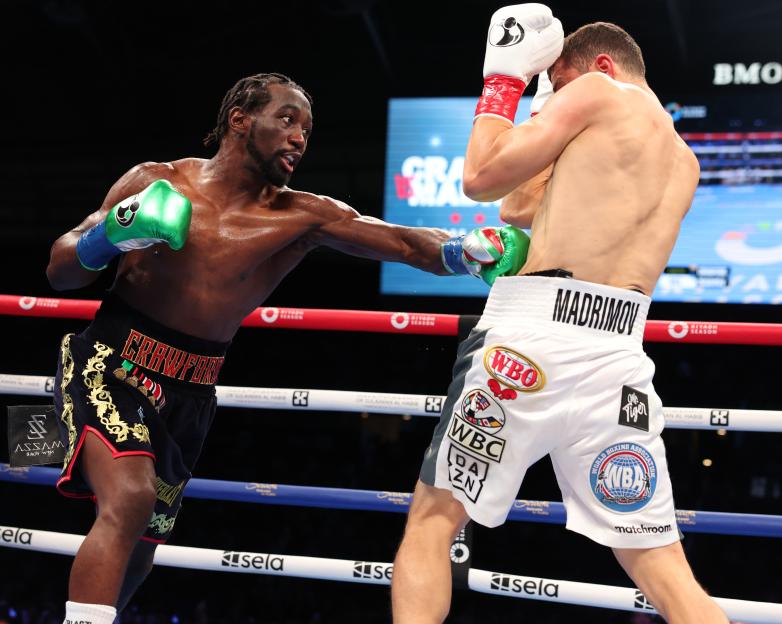 Terence Crawford (black and gold shorts) boxing Israil Madrimov (white shorts).