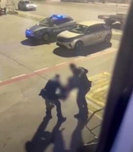 Police removing disruptive passengers at an airport.