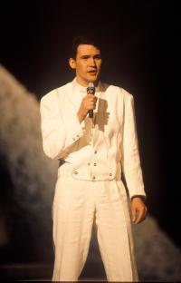 Johnny Logan singing into a microphone.