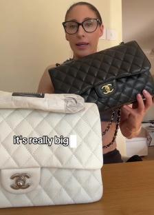 Woman holding a black and a white quilted Chanel handbag.