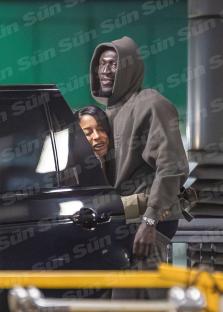 Stormzy and Victoria Monet embracing at an airport.
