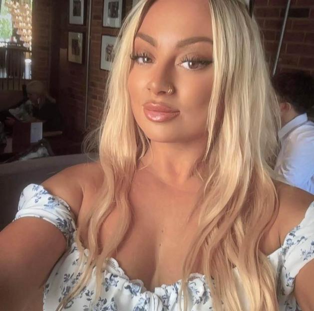 Selfie of a blonde woman wearing an off-the-shoulder floral top.