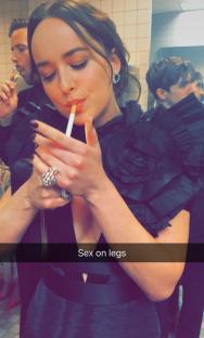 Dakota Johnson lighting a cigarette.