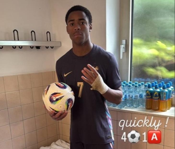Soccer player in uniform holding a ball.