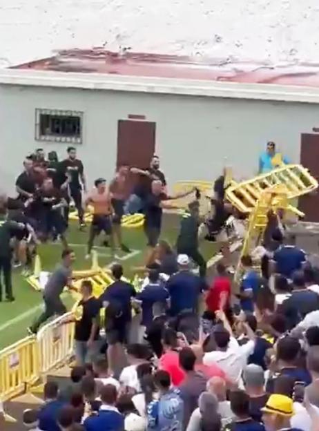 Sports fans fighting and throwing objects.