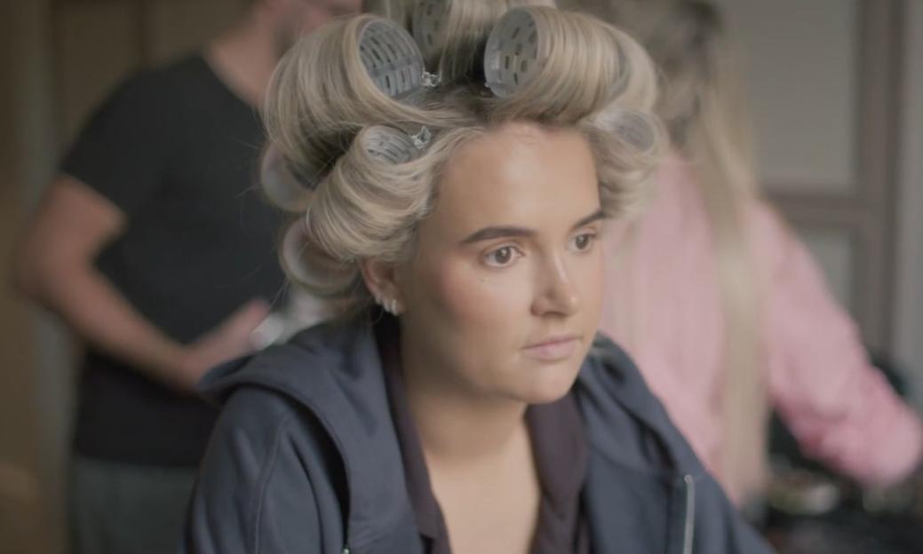 Molly-Mae Hague with hair curlers, looking concerned.