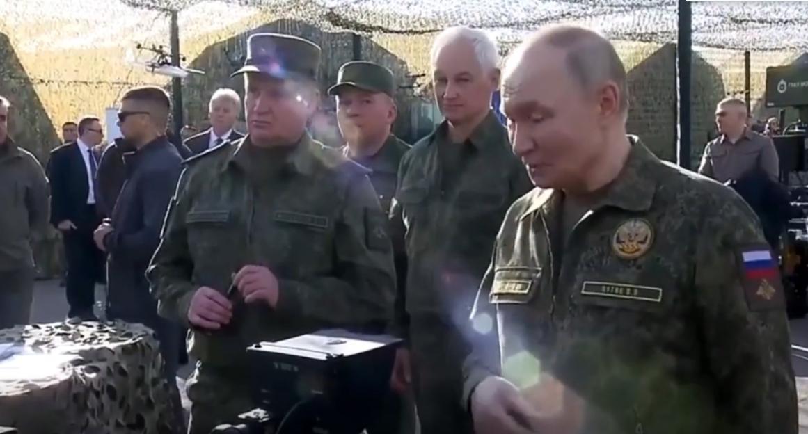 Vladimir Putin and other military officials at a military exercise.
