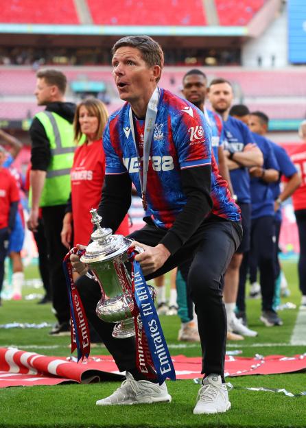 Crystal Palace manager holding the Emirates FA Cup trophy.