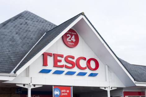 Tesco 24-hour supermarket entrance sign.