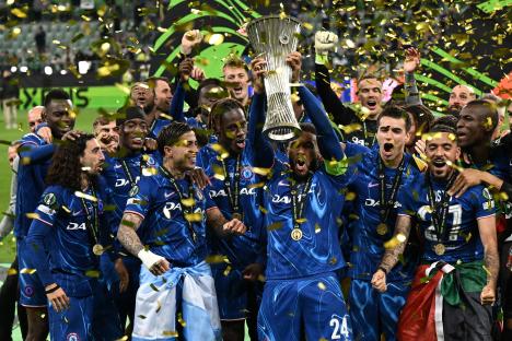 Chelsea players celebrating with the UEFA Conference League trophy.