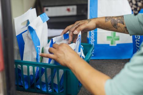 Pharmacist sorting prescription bags.