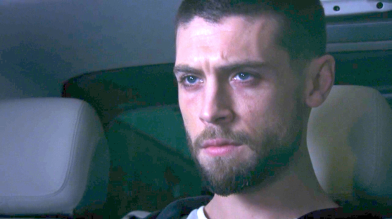 Screenshot of a man sitting in a car.