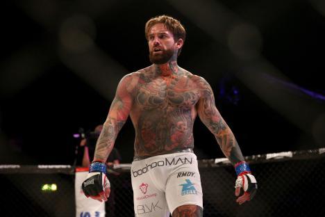 Aaron Chalmers celebrating a victory in a mixed martial arts fight.