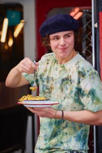 Young man eating mac and cheese.