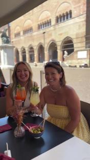 Two women enjoying cocktails at an outdoor cafe.