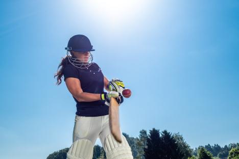 Woman cricket player batting.