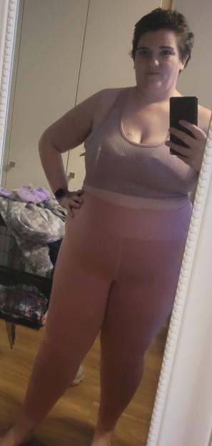 Woman taking a selfie in a mirror wearing athletic wear.