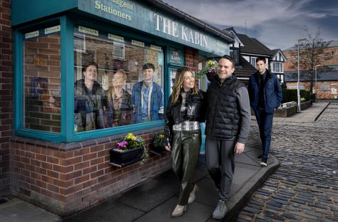 Coronation Street actors walking past The Kabin shop.