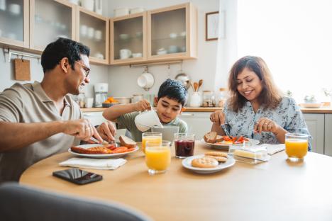 Family of three enjoying breakfast together in their kitchen.