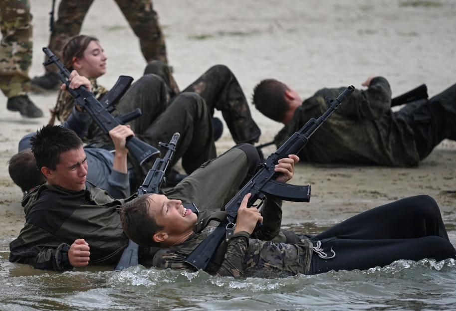 Cadets in military training exercise in shallow water.